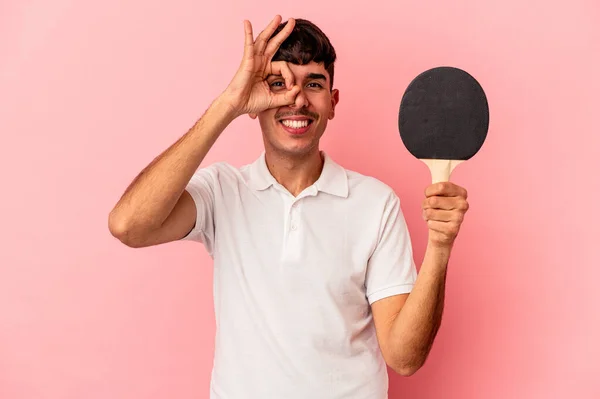 若いです混合レース男保持A Ping Pongラケット孤立オンピンク背景励起保つOkジェスチャー上の目 — ストック写真