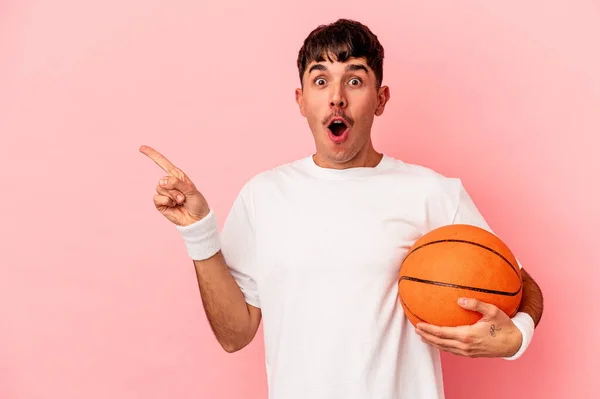 Młody Mieszane Wyścig Człowiek Gra Koszykówkę Odizolowany Różowym Tle Wskazując — Zdjęcie stockowe