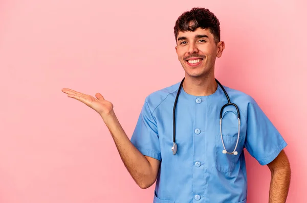 Joven Enfermero Raza Mixta Aislado Sobre Fondo Rosa Mostrando Espacio —  Fotos de Stock