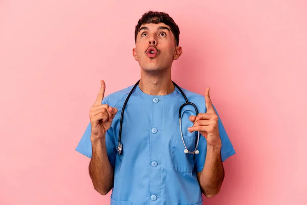 Jovem Mista Enfermeira Homem Isolado Fundo Rosa Apontando Cabeça Com — Fotografia de Stock