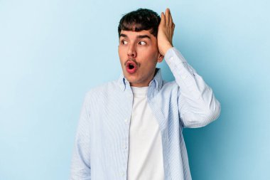 Genç melez adam mavi arka planda izole edildi şok oldu, önemli bir toplantı hatırladı.