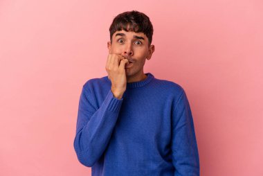 Pembe arka planda yaşayan, tırnaklarını yiyen, gergin ve endişeli genç bir ırk..