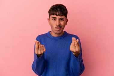 Genç melez adam, pembe arka planda izole edilmiş, parasız olduğunu gösteriyor..