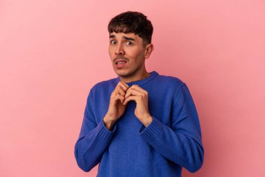 Genç melez adam pembe arka planda izole edilmiş korkmuş ve korkmuş..