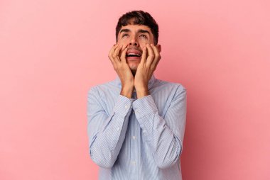 Genç melez adam, pembe arka planda izole edilmiş sızlanıyor ve ağlıyordu..