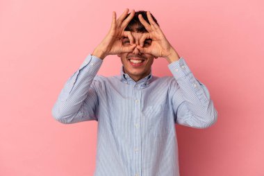 Genç melez adam pembe arka planda izole edilmiş, gözlerinde sorun yok işareti var.