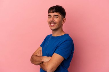 Genç melez adam pembe arka planda izole edilmiş mutlu, güler yüzlü ve neşeli.