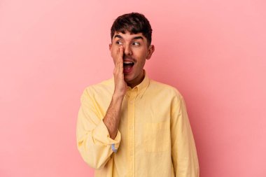 Genç melez adam pembe arka planda izole edilmiş, heyecanlı bir şekilde bağırıyor..