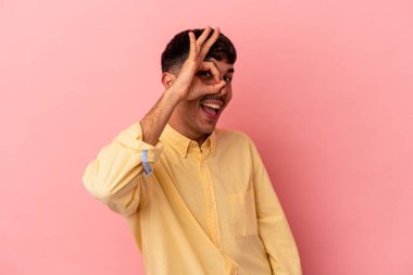 Genç melez adam, pembe arka planda izole edilmiş. Heyecanlı..