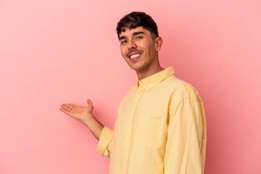 Pembe arka planda soyutlanmış genç melez bir adam hoş bir yüz ifadesi sergiliyor..