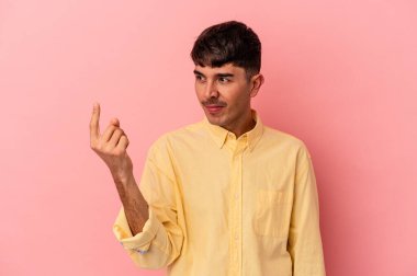 Genç melez adam pembe arka planda izole edilmiş seni işaret ediyor sanki davet ediyormuş gibi..