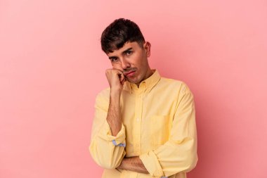 Pembe arka planda izole edilmiş genç melez adam tekrarlanan bir görevden yoruldu..