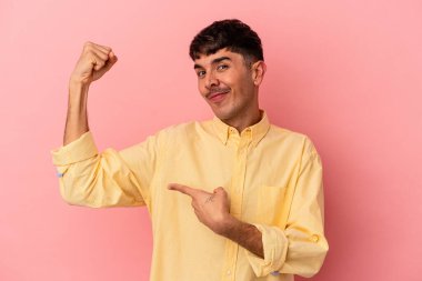 Pembe arka planda izole edilmiş genç melez kadın gücünün sembolü olan kollarla güçlü bir hareket gösteriyor.