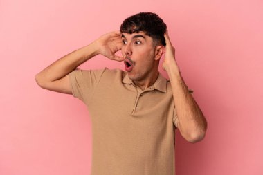 Genç melez adam pembe arka planda izole edilmiş bağırıyor, çok heyecanlı, tutkulu, bir şeyden memnun..