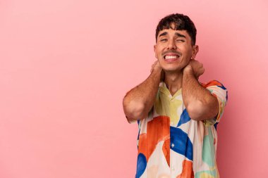 Genç melez adam pembe arka planda izole edilmiş kafasının arkasına dokunuyor, düşünüyor ve bir seçim yapıyor..