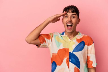 Pembe arka planda izole edilmiş genç bir ırk yüksek sesle bağırıyor, gözleri açık ve elleri gergin tutuyor..