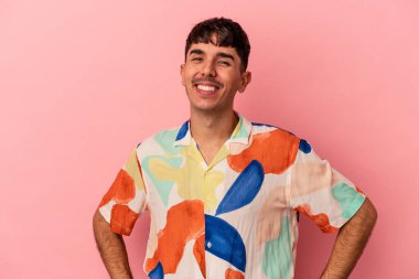 Genç melez adam pembe arka planda izole edilmiş mutlu, güler yüzlü ve neşeli.