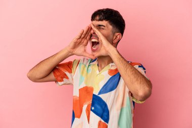 Genç melez adam pembe arka planda izole edilmiş, heyecanlı bir şekilde bağırıyor..