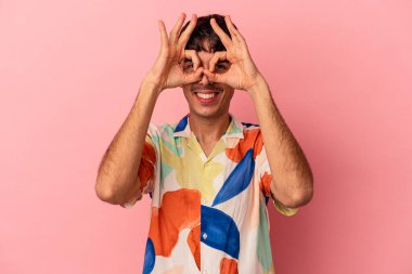 Genç melez adam, pembe arka planda izole edilmiş. Heyecanlı..