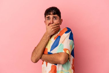 Genç melez adam pembe arka planda izole edilmiş korkmuş ve korkmuş..