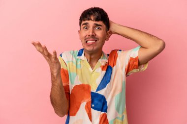 Genç melez adam pembe arka planda izole edilmiş öfkeyle bağırıyor..