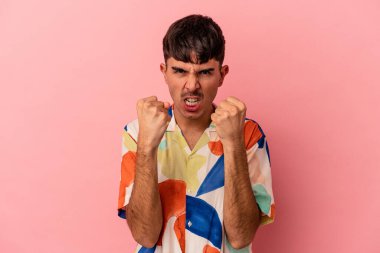 Genç melez adam pembe arka planda izole edilmiş gergin ellerle çığlık atıyor..