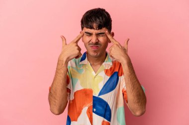 Pembe arka planda izole edilmiş genç melez bir adam bir göreve odaklanmış, işaret parmaklarını işaret ediyor..