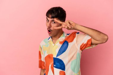 Genç melez adam pembe arka planda izole edilmiş dans ediyor ve eğleniyor..