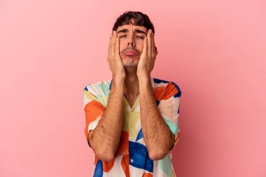 Genç melez adam, pembe arka planda izole edilmiş sızlanıyor ve ağlıyordu..