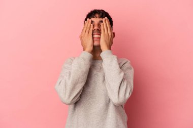 Pembe arka planda soyutlanmış genç melez adam ellerini başının üstünde tutarak neşeyle gülüyor. Mutluluk kavramı.