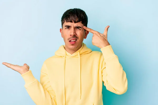 Ung Blandras Man Isolerad Blå Bakgrund Innehav Och Visar Produkt — Stockfoto