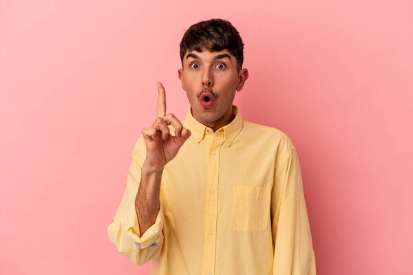 Молодой смешанной расы человек изолирован на розовом фоне, имея некоторые большие идеи, концепция творчества.