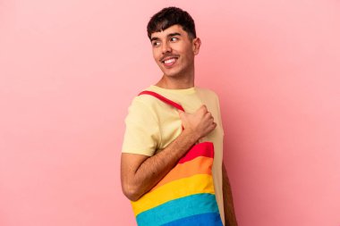 LGTB çanta giyen genç melez adam pembe arka planda izole edilmiş.