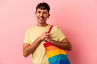 LGTB çanta giyen genç melez adam pembe arka planda izole edilmiş.
