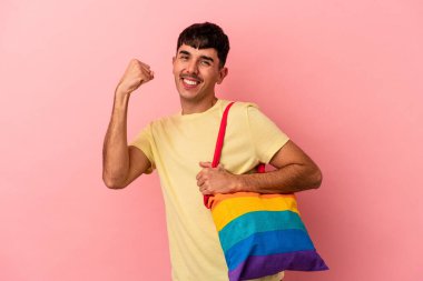 LGTB çanta giyen genç melez adam pembe arka planda izole edilmiş.