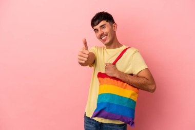 LGTB çanta giyen genç melez adam pembe arka planda izole edilmiş.