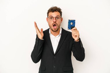 Beyaz arka planda HDD 'yi tutan beyaz bilgisayarlı genç şaşırmış ve şok olmuştu..