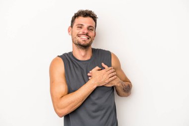 Beyaz arka planda izole edilmiş beyaz tenli genç bir adam, dostane bir ifadeye sahip, avuçlarını göğsüne bastırıyor. Aşk konsepti.