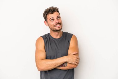 Beyaz arka planda izole edilmiş genç beyaz adam hedeflere ve amaçlara ulaşmayı hayal ediyor.