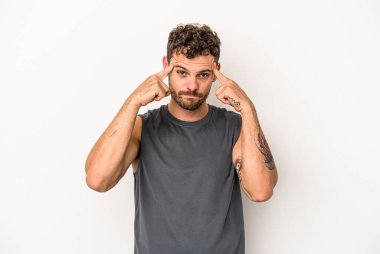 Beyaz arka planda izole edilmiş genç beyaz bir adam bir göreve odaklanmış, işaret parmaklarını işaret ediyor..