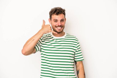 Beyaz arka planda izole edilmiş genç beyaz bir adam parmakları olan bir cep telefonu hareketi gösteriyor..