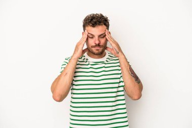 Beyaz arka planda izole edilmiş genç beyaz bir adam tapınaklara dokunuyor ve başı ağrıyor..