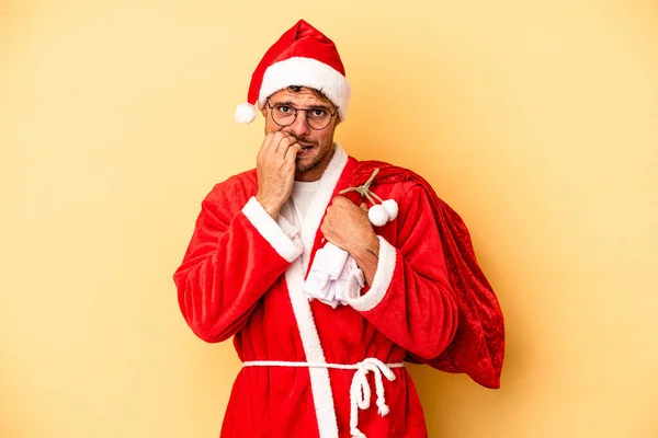 Jonge Blanke Man Vermomd Als Kerstman Geïsoleerd Gele Achtergrond Bijtende — Stockfoto