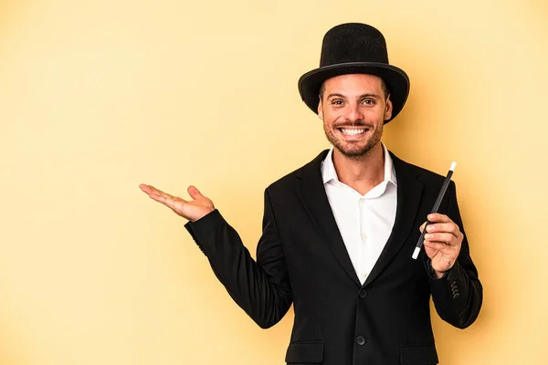 Young Caucasian Wizard Holding Wand Isolated Yellow Background Showing Copy — Stock Photo, Image