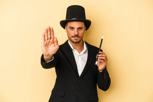 Young Caucasian Wizard Holding Wand Isolated Yellow Background Standing Outstretched — Stock Photo, Image