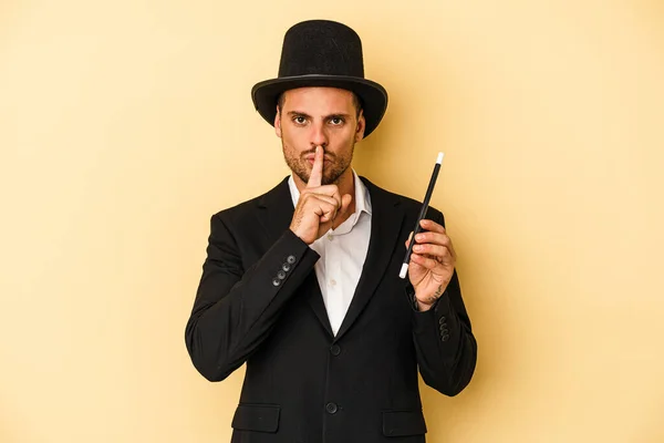 Young Caucasian Wizard Holding Wand Isolated Yellow Background Keeping Secret — Stock Photo, Image