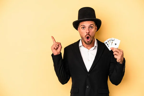 Young Caucasian Wizard Holding Magic Card Isolated Yellow Background Pointing — Stock Photo, Image