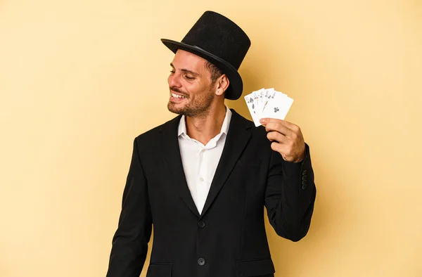 Young Caucasian Wizard Holding Magic Card Isolated Yellow Background Looks — Stock Photo, Image