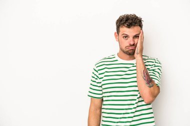 Beyaz arka planda izole edilmiş, üzgün ve dalgın hisseden genç beyaz bir adam fotokopi alanına bakıyor..