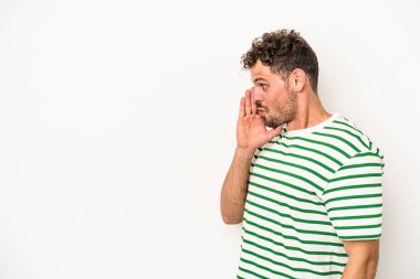 Beyaz arka planda izole edilmiş genç beyaz bir adam gizli bir sıcak fren haberi veriyor ve yana bakıyor.